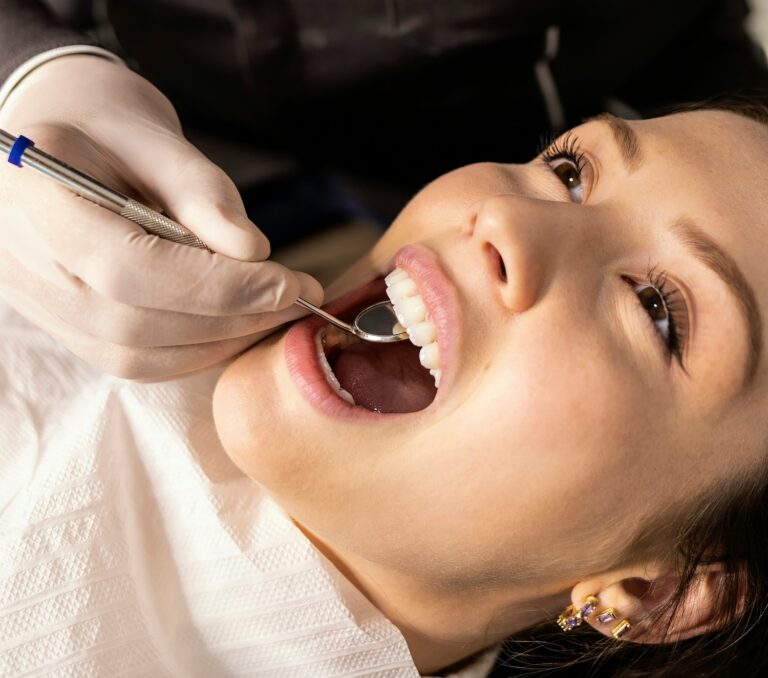 Dentist examining a child’s teeth with a mirror during a dental checkup